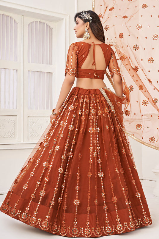 Tempting Net Fabric Rust Color Lehenga Choli With Embroidered Work